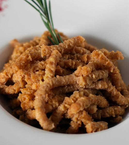 Passatelli-Nudeln aus Dinkelmehl (mit Tomaten und Basilikumsauce) mit Butterschmalz