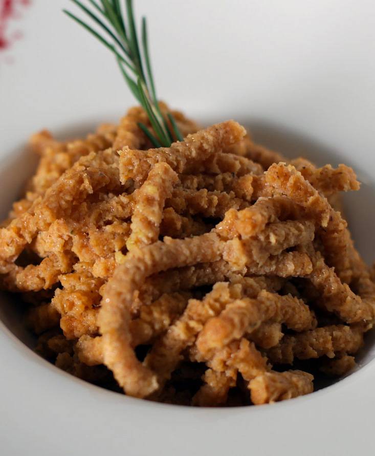 Passatelli-Nudeln aus Dinkelmehl (mit Tomaten und Basilikumsauce) mit Butterschmalz