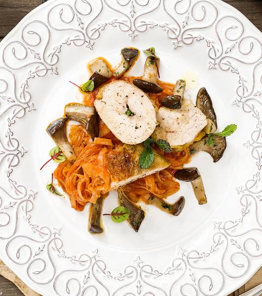 Suprême vom perlhuhn mit in tomaten geschmortem lauch und gedünsteten kräuterseitlingen